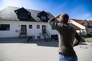 Mann blickt auf ein neugebautes Wohnhaus